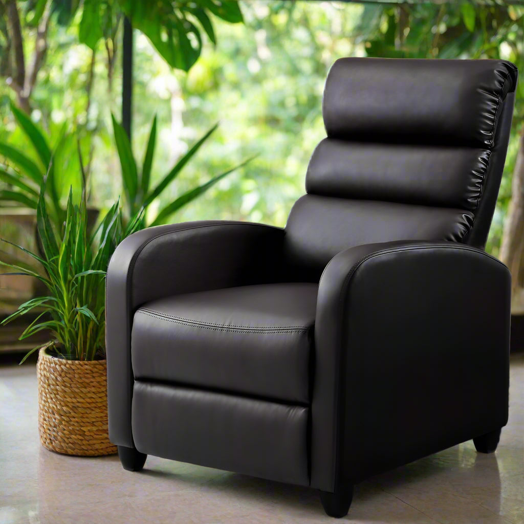 Black leather recliner chair against a textured gray wall with a plant on a wooden floor.